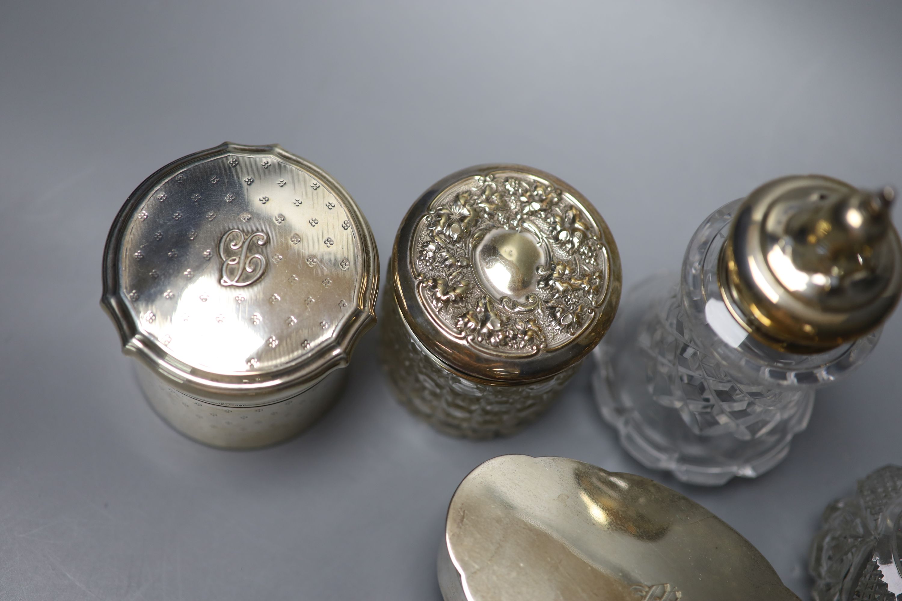 A George V silver oval trinket box, 12.5cm, a silver toilet canister and other toilet jars etc.